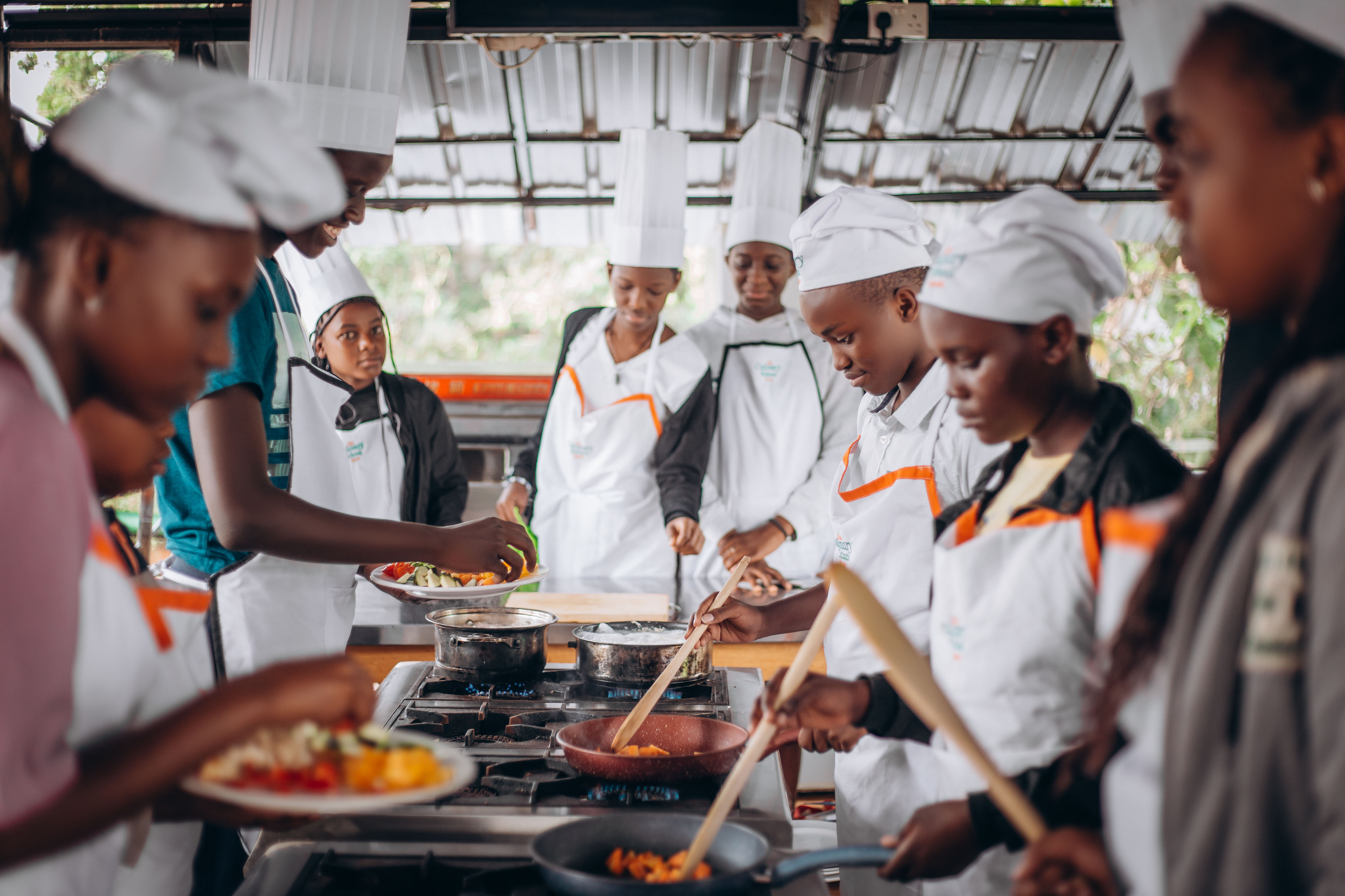 man watching a band on the stage wearing a red t-shirt and black hat.